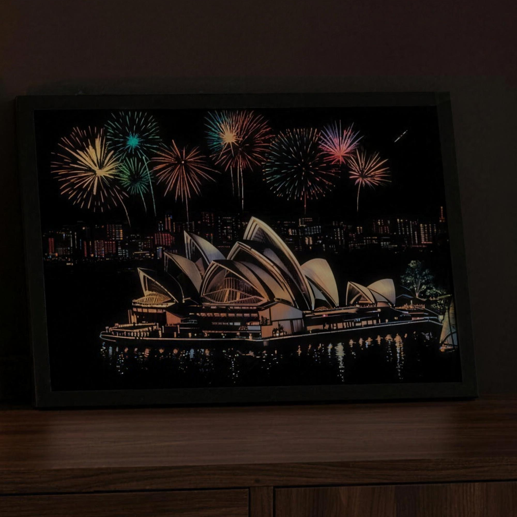 The Scratchlight Frame in black wood holding a finished Sydney Opera House scratch art card