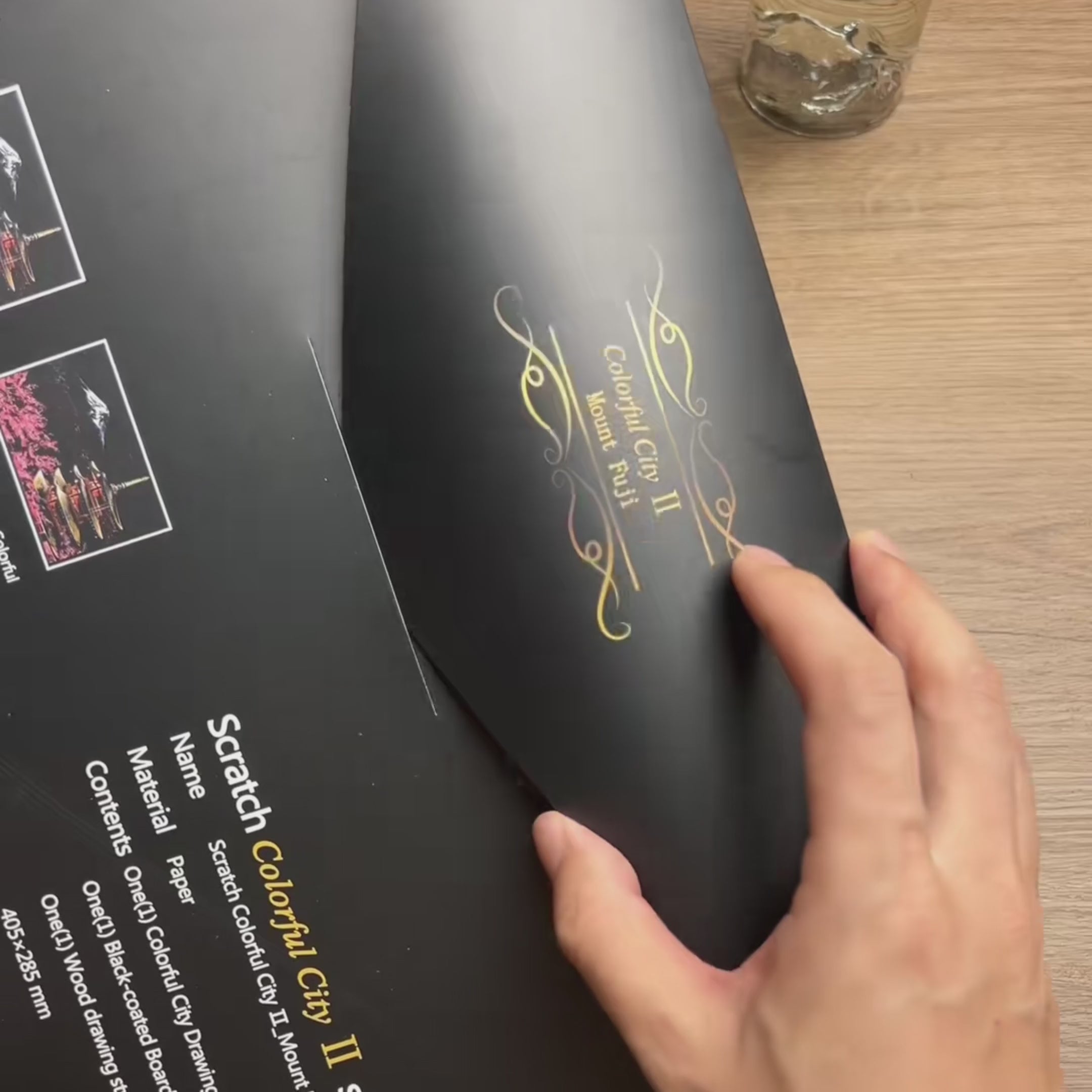 Opening the kit, scratching the matte black card with the bamboo stylus, then the finished Mount Fuji scene glowing in full color