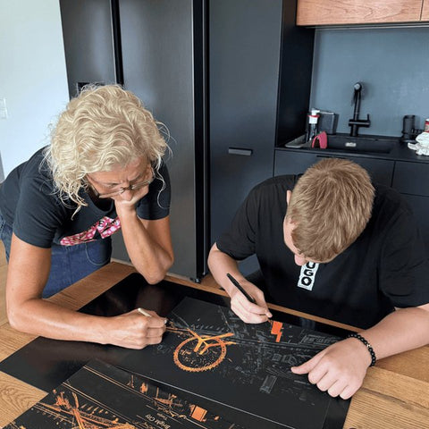 Two people scratching their city cards at a kitchen table, photographed at home